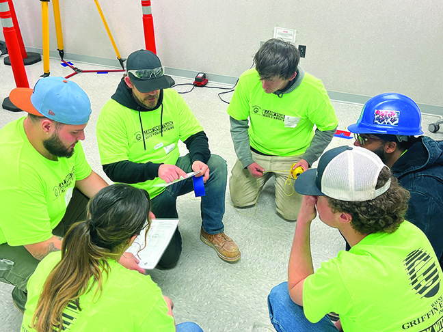 A group of construction workers in hard hats and safety vests.