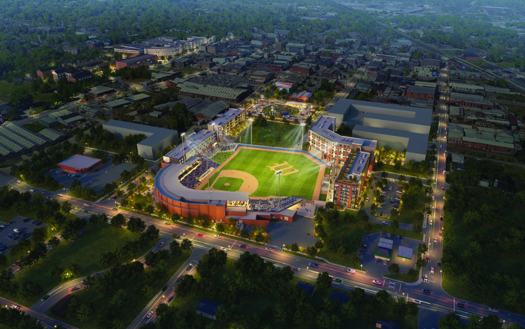 Aerial view of a baseball stadium illuminated at night in a city.